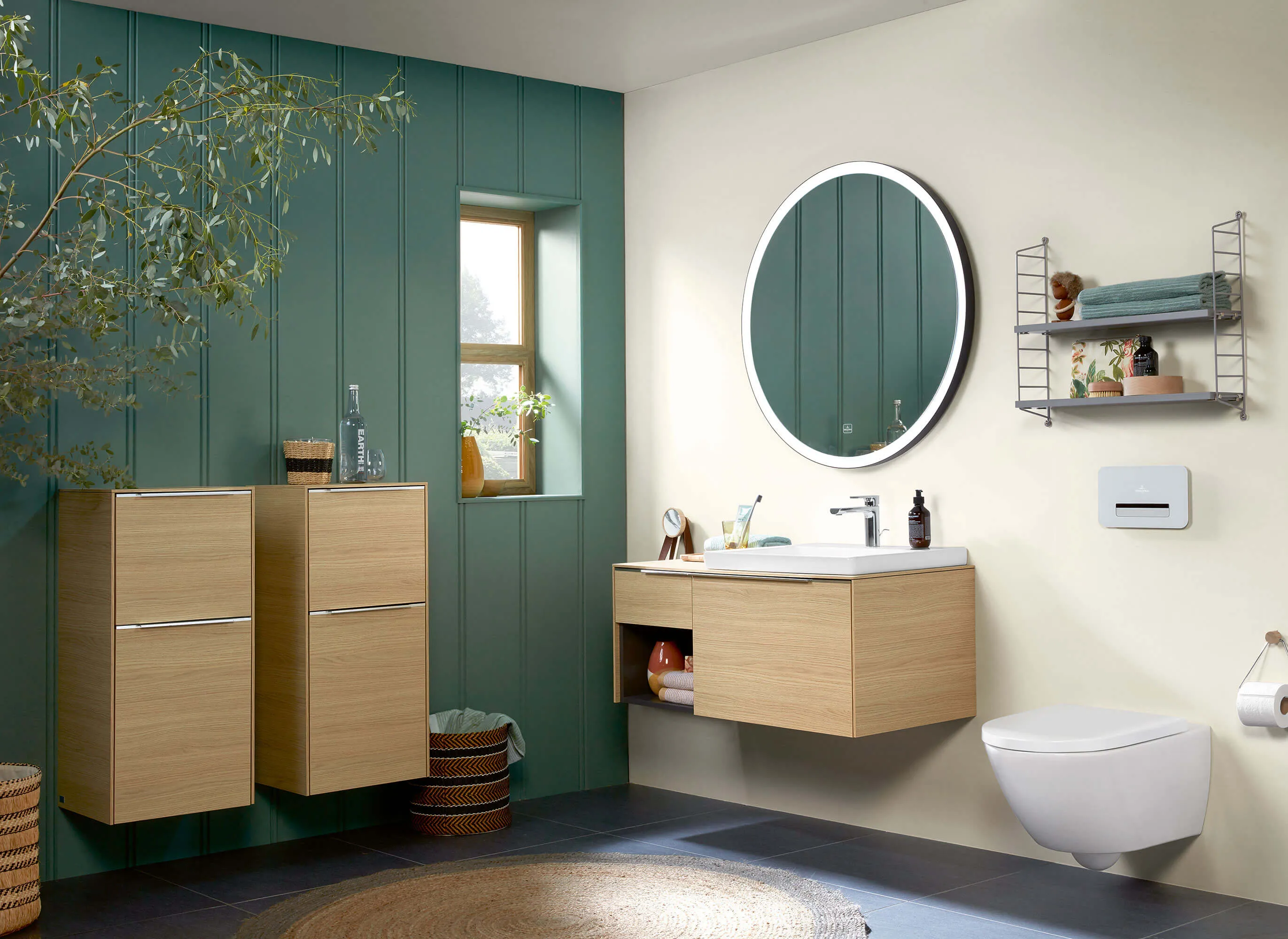 Mobili da bagno Subway 3.0 con lavabo e WC in un bagno accogliente con parete verde e finestra.