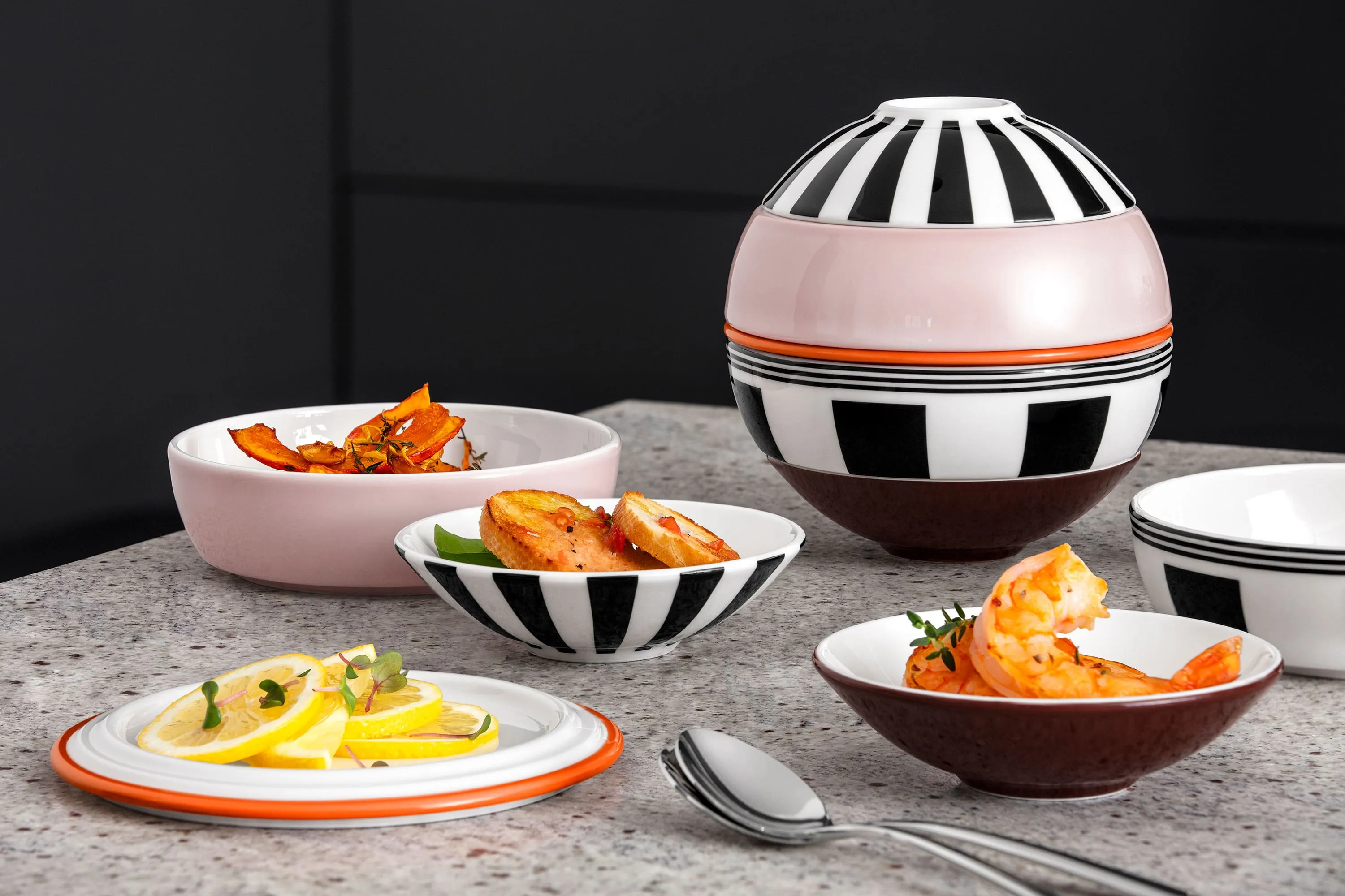 Various dishes, including prawns and lemon slices, being served in the La petite Boule individual bowls.