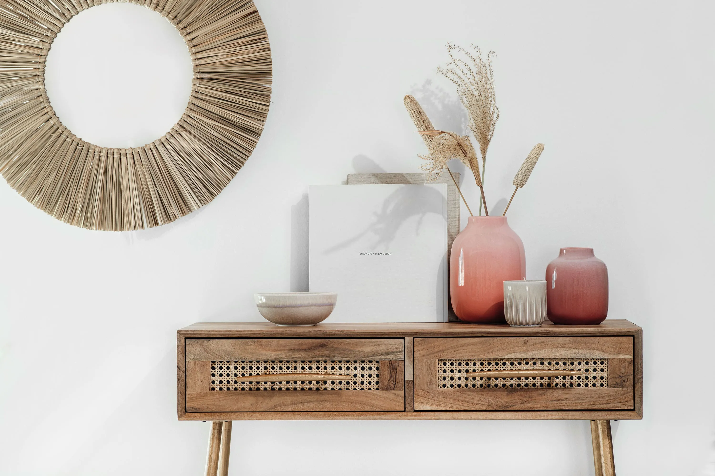 Vases Perlemor sur une console en bois Une console en bois avec des vases Perlemor et un miroir rond.