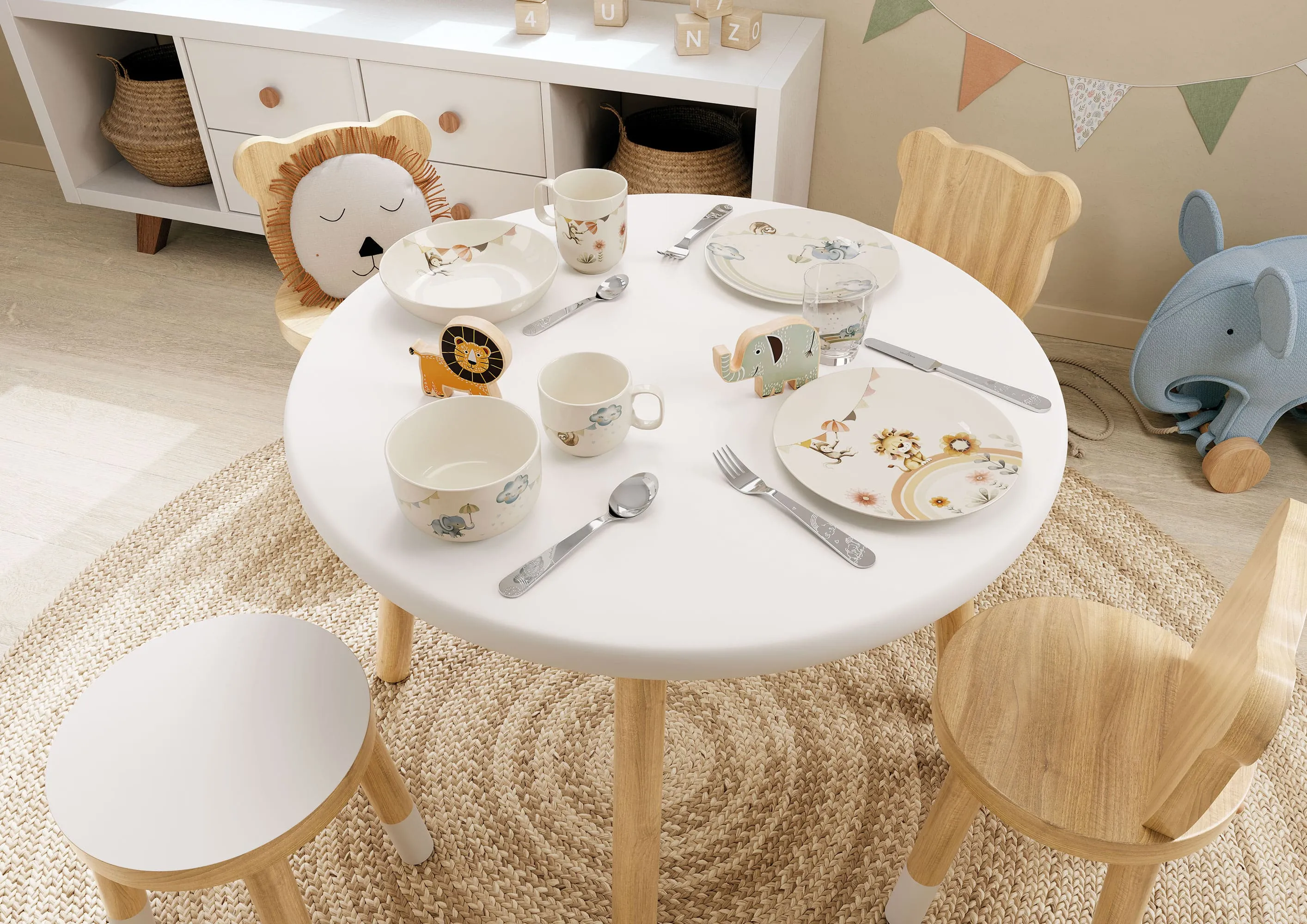 De la vaisselle Boho Kids dressée sur une petite table dans une chambre d’enfant Une table dressée dans une chambre d’enfant avec de la vaisselle Boho-Kids, des couverts de table et des verres sur le thème des animaux dans des couleurs pastel.