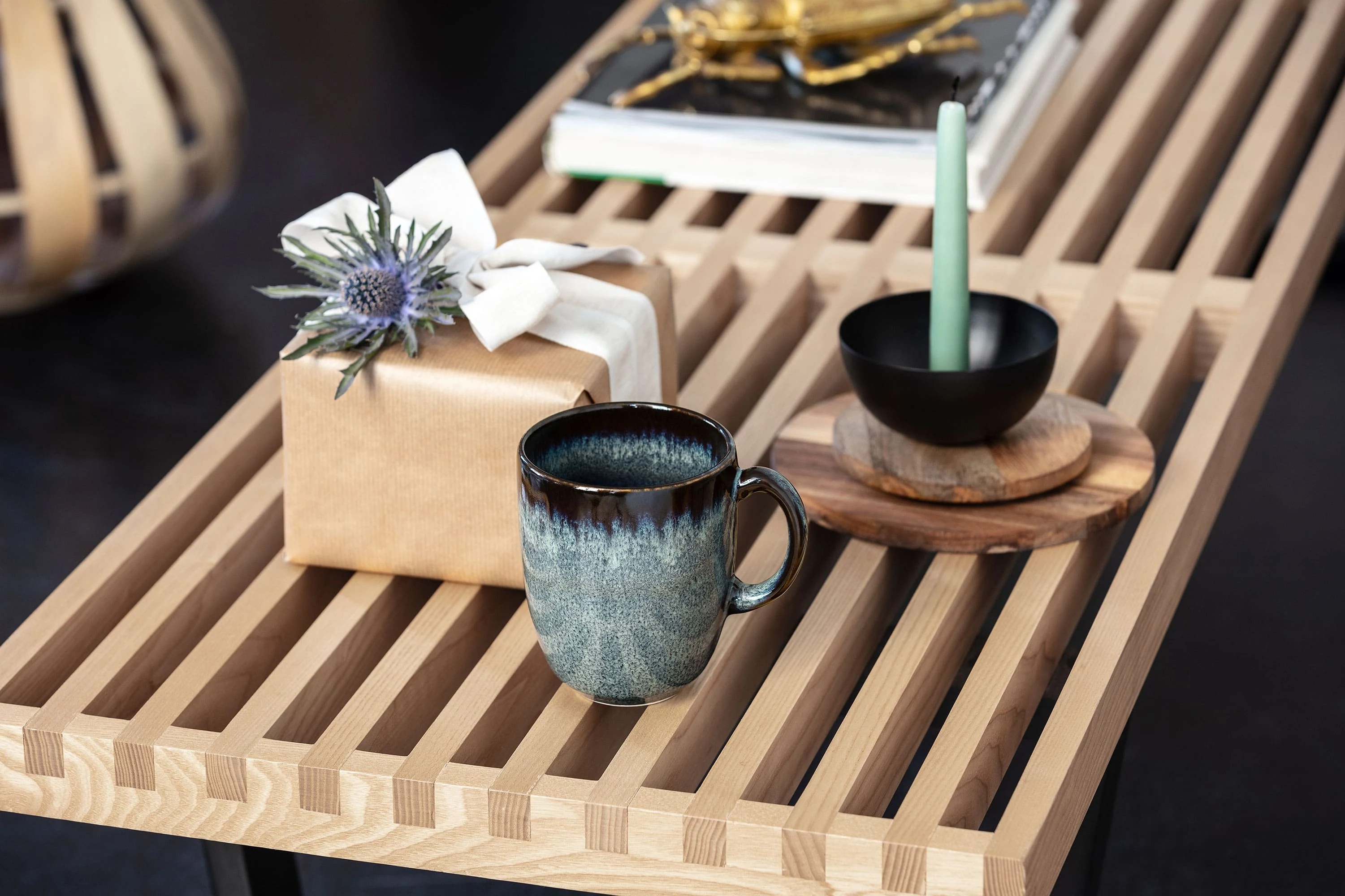 Lave Becher, Geschenkbox mit Schleife und Schüssel auf Holztablett, auf elegantem Tisch.