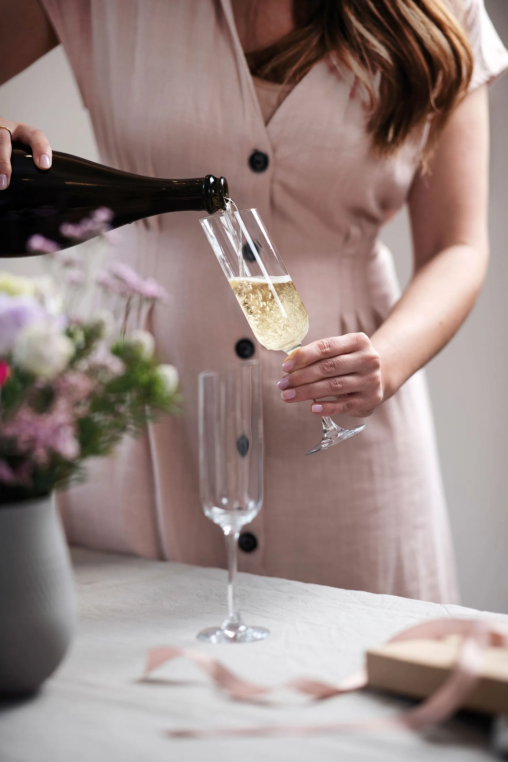 Flûte à champagne NewMoon contant du champagne Une femme verse du champagne dans une flûte à champagne NewMoon de Villeroy & Boch.