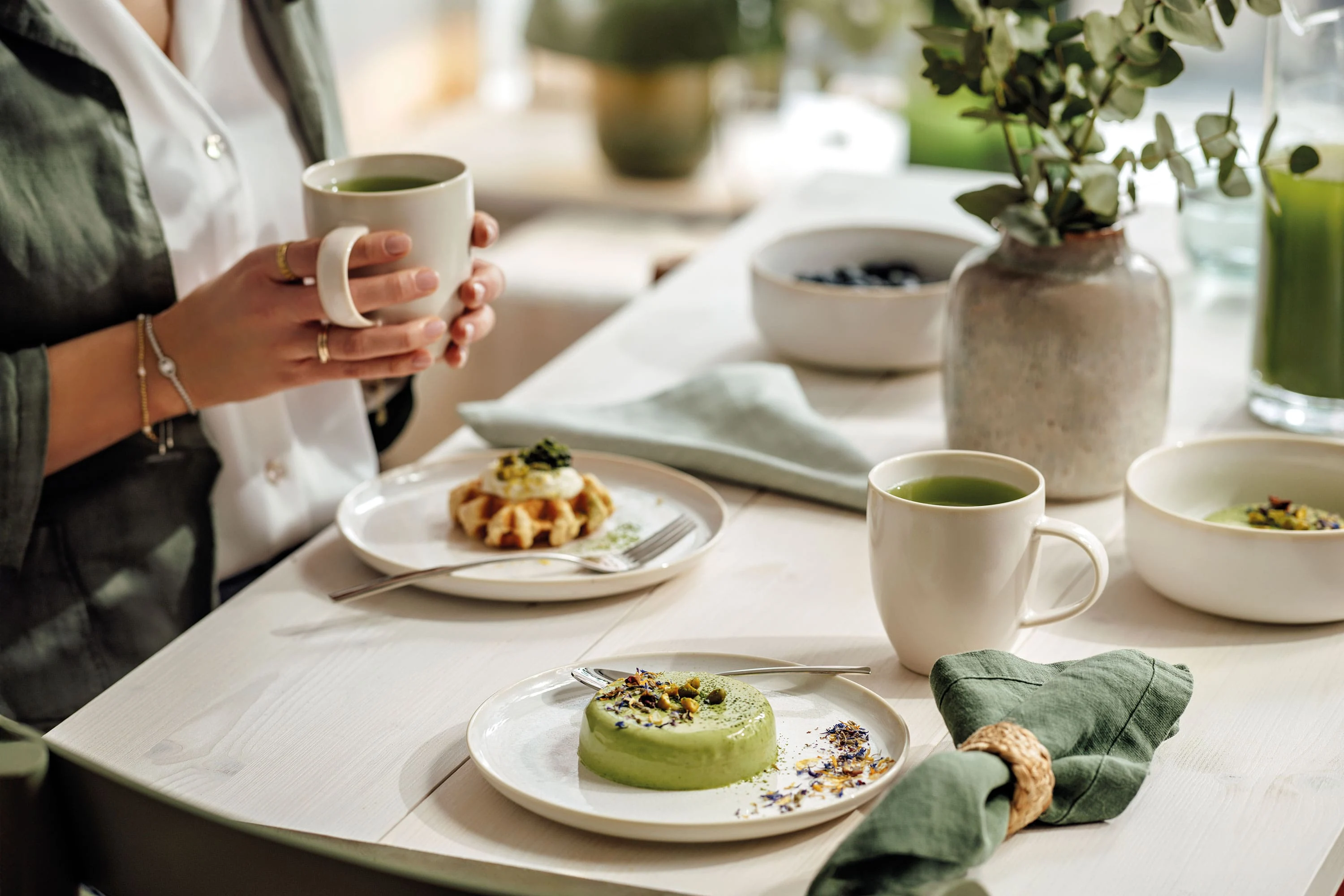 Villeroy & Boch Crafted Cotton Cups and Plates Light beige porcelain mug and cake plate Crafted Cotton with a fresh waffle and hot tea on a wooden table.