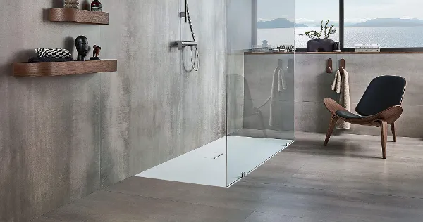 A modern grey bathroom with a Squaro Infinity shower tray and a brown chair.