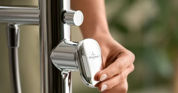 A woman's hand operating the design bath tap from the Villeroy & Boch Antao collection.