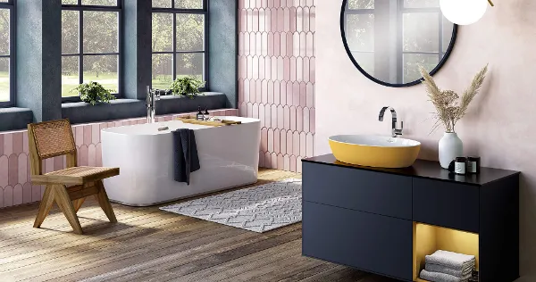 A yellow Artis washbasin on a dark vanity unit in a bathroom with a wooden floor and pink tiles.