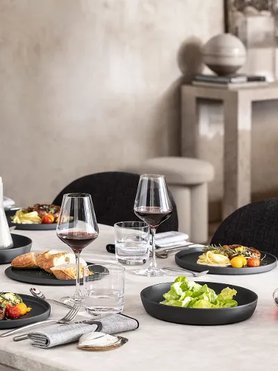 A dining table with a black La Boule being used for food as well as a fully assembled La Boule for decoration.