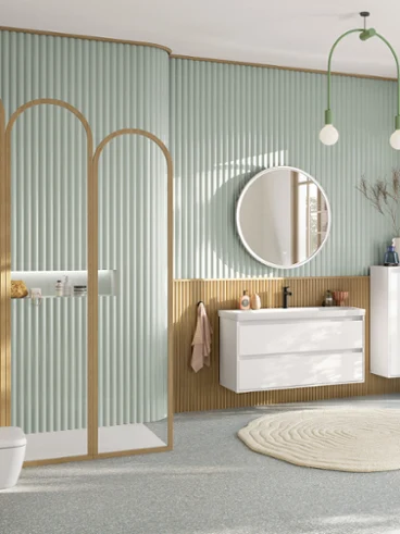 Ampio bagno familiare verde pastello con area doccia, mobile lavabo con mobile base bianco, specchio rotondo illuminato, mobile laterale, rubinetteria nera e WC sospeso rettangolare della collezione Skyla.