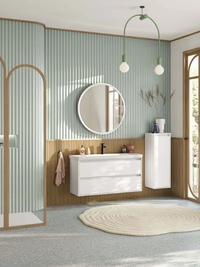 Speelse, pastelgroene badkamer met Villeroy & Boch collectie Skyla. Grote, pastelgroene familiebadkamer met doucheruimte, wastafelmeubel met witte onderkast, ronde verlichte spiegel, zijkast, zwarte kranen en rechthoekig, wandhangend toilet uit de Skyla collectie.