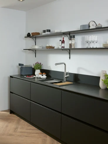 Subway Style Shower kitchen tap in a black kitchen A Subway Style Shower solid stainless-steel kitchen tap in a black kitchen with shelves and sink.