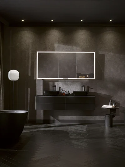Czarna łazienka z wanną wolnostojącą i podwójną umywalką Dramatyczna, całkowicie czarna łazienka Artis z wanną wolnostojącą, podwójną umywalką, podświetlanym lustrem i miękkim oświetleniem, tworząca śmiałą i luksusową atmosferę.