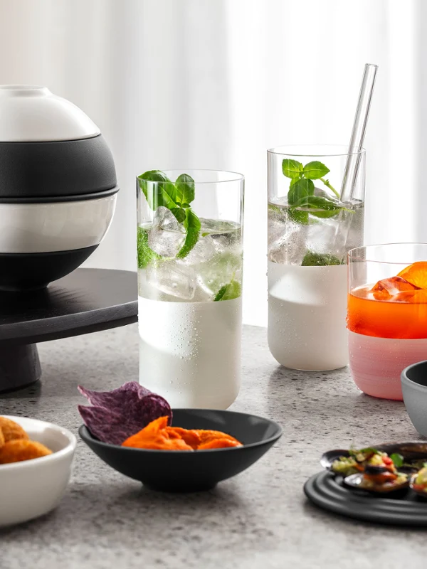 La petite Boule black and white on a marble countertop Black and white La petite Boule presenting various starters on a marble countertop, including deep-fried canapés, purple crisps, skewers and drinks with garnishes.