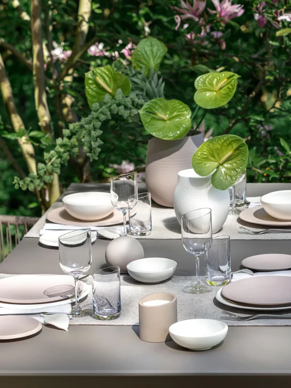 Table set with the NewMoon collection A dining table with Villeroy & Boch NewMoon tableware in a garden.