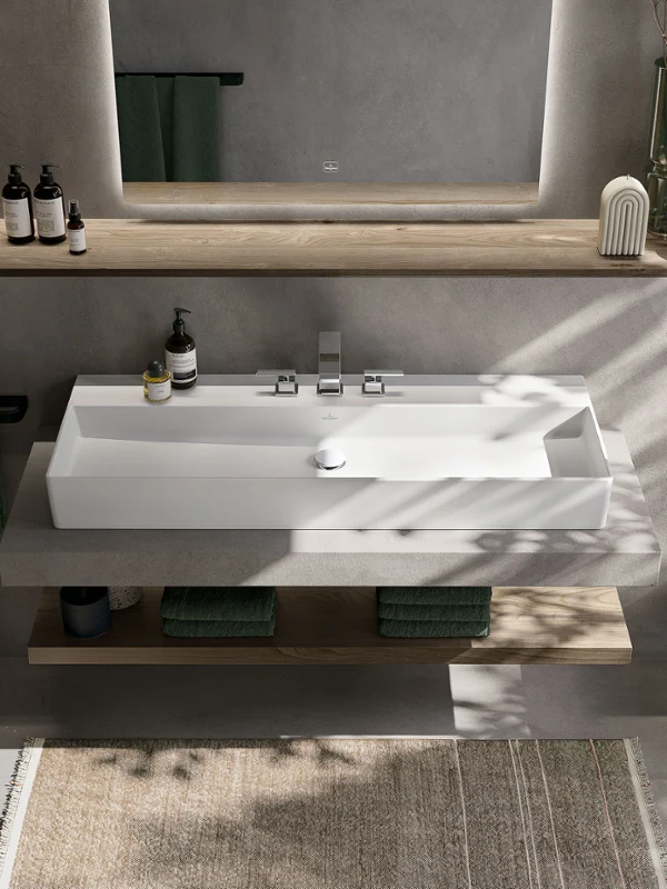 Hvit rektangulær Stone White servant på betongservantskap med trehylle Memento 2.0 Stone White servant i Stone White med presise konturer og minimalistisk design, integrert i et moderne baderom med naturlige aksenter.