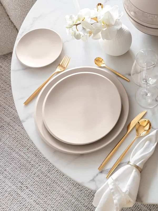 A table set with Villeroy & Boch beige NewMoon plates and gold MetroChic cutlery