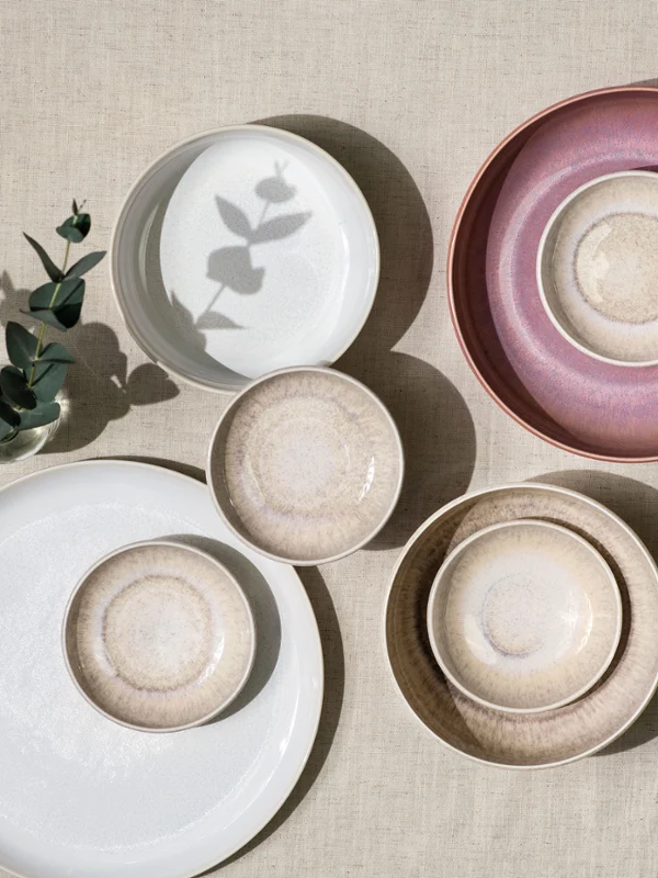 Crafted und Perlemor Teller in Pastelltönen, arrangiert auf einer neutral strukturierten Oberfläche.