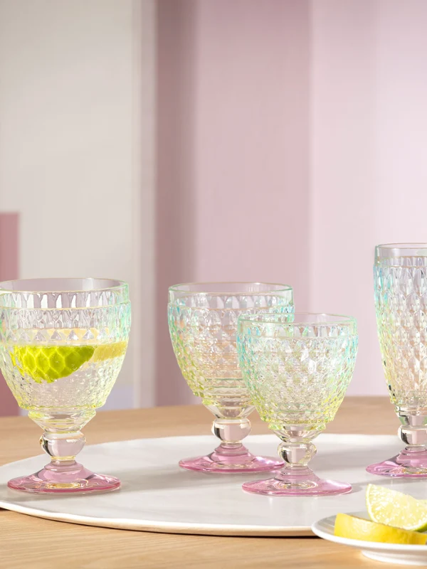 Juego de seis vasos Boston Pearl Un juego de seis vasos de cristal Villeroy & Boch Boston Pearl sobre una mesa de madera con rodajas de lima y limón, un vaso con pajita y una rodaja de limón.