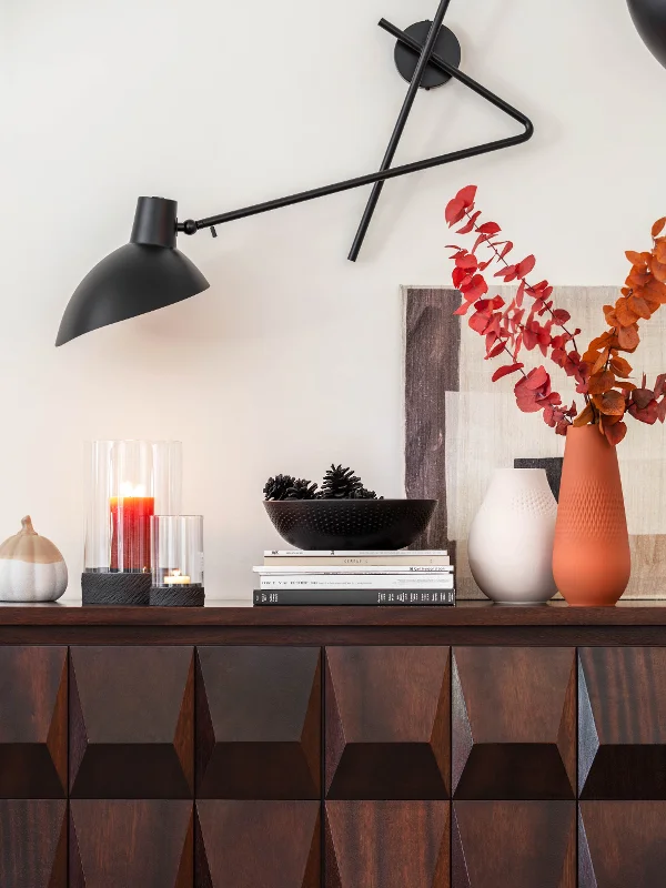 Credenza moderna con elementi decorativi Manufacture e un'applique regolabile.
