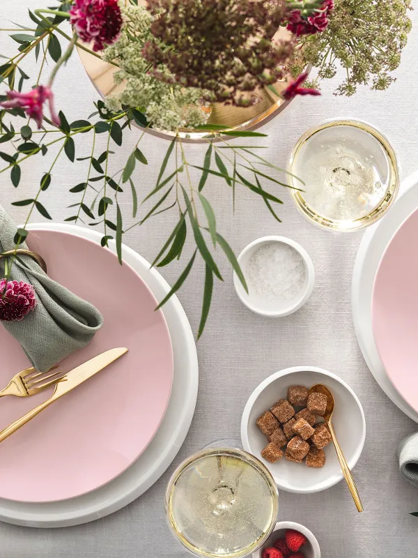 Elegant table decorations with pink Rose Garden plates, golden MetroChic flatware, fresh flowers and a touch of green, plus drinks and light snacks.