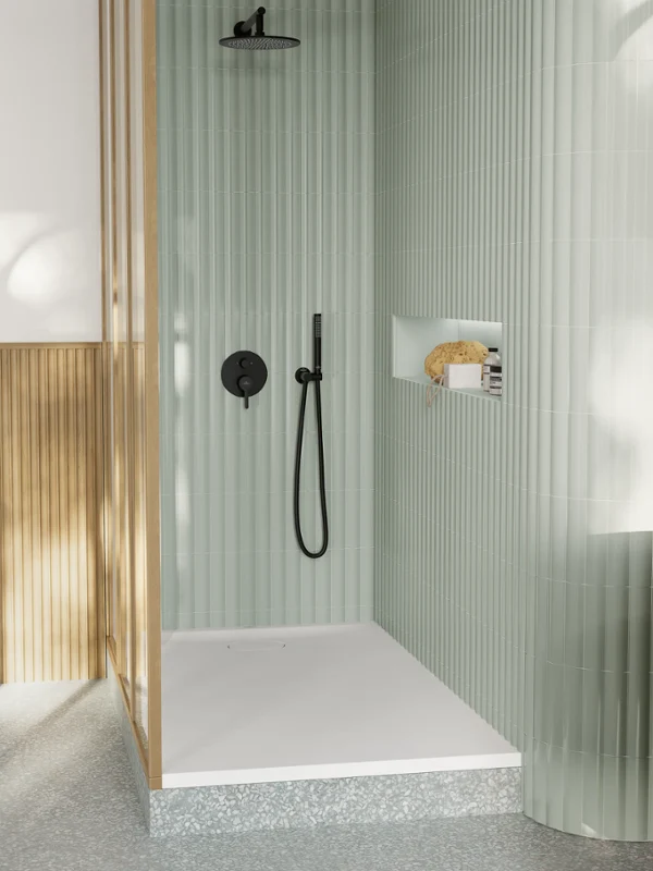 Villeroy & Boch Ecora shower tray installed on a raised plinth in a sage-green shower with black fittings.