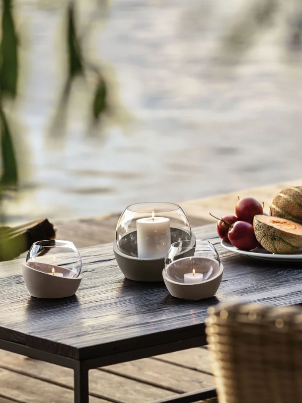 NewMoon hurricane lamp on a wooden table NewMoon hurricane lamps on a wooden table with fruit and wine.