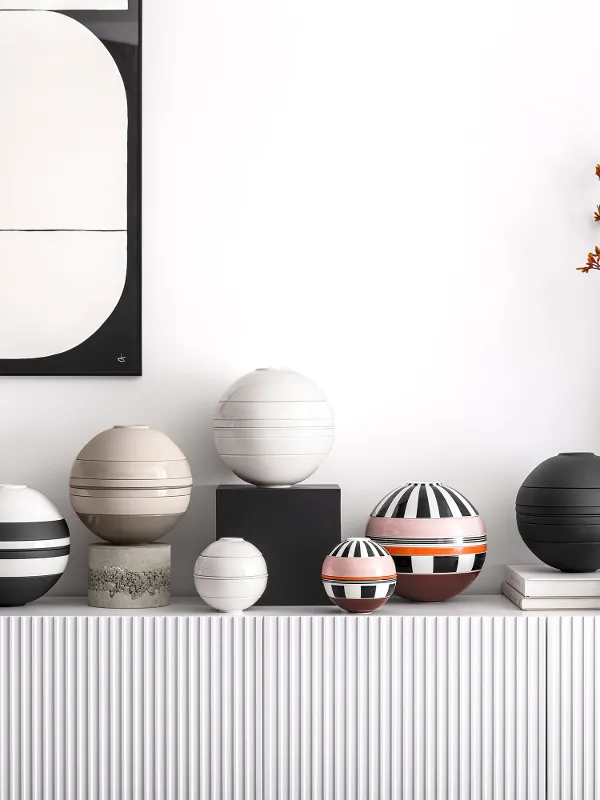 Auf einem gestreiften Schrank stehen verschiedene Farben der La Boule & La petite Boule.