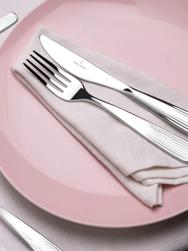 Rose Garden bestek van Villeroy & Boch op een roze Rose Garden bord versierd met bloemen.