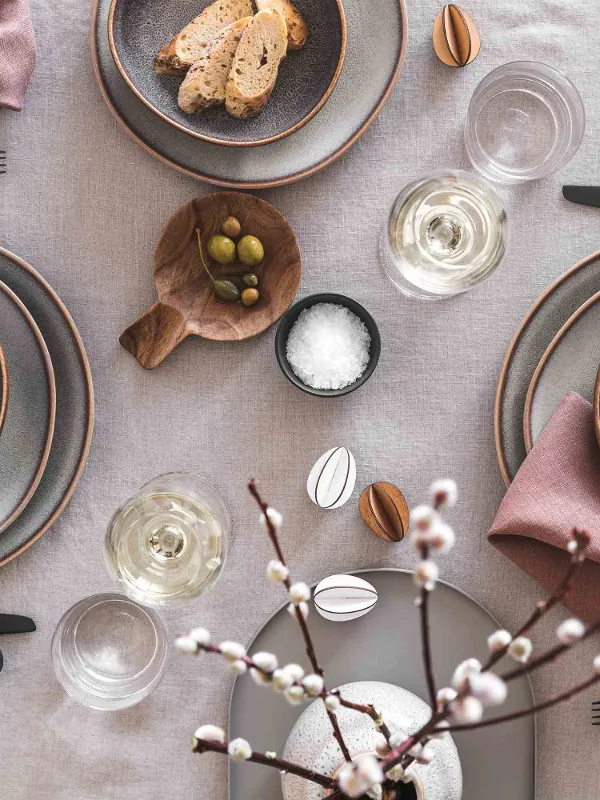 Elegant table decorations with Lave dinnerware, Manufacture flatware and simple Easter decorations in a neutral color palette.