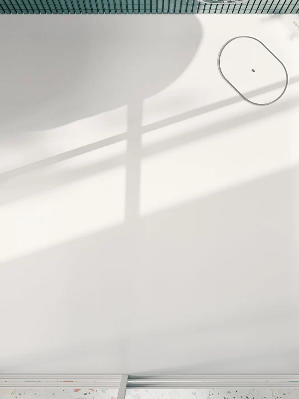 Top-down view of a Villeroy & Boch Ecora shower tray with oval waste cover in a shower clad in green mosaic tiles.