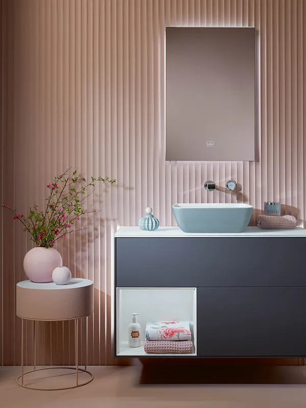 Finion dark-blue vanity unit by Villeroy & Boch in a pink bathroom with a pink coffee table.