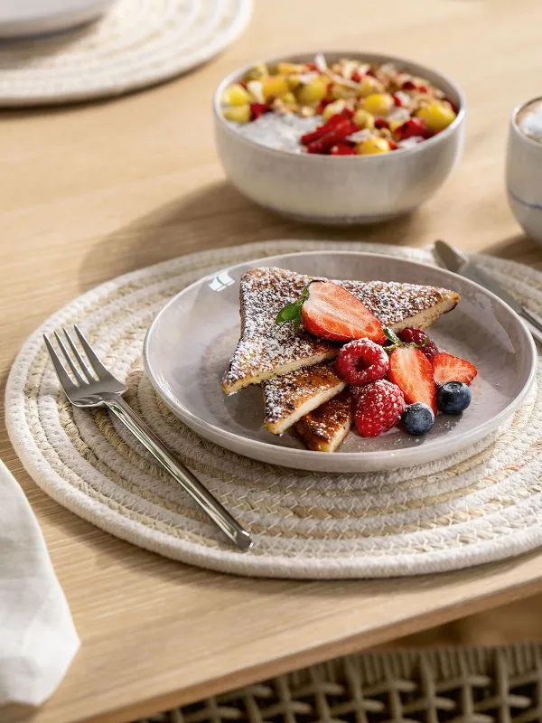 Apparecchiatura boho per colazione e dessert con stoviglie Villeroy & Boch Perlemor Sand – tazza, ciotola per muesli e piatto – su tavolo in legno rustico dal fascino naturale e rilassato.