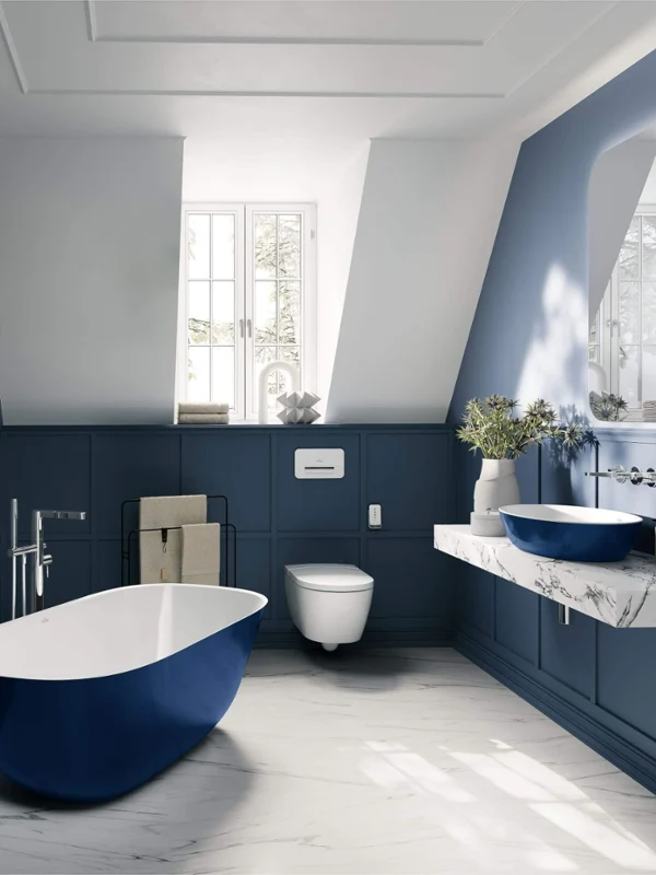 Baño con techo inclinado de estilo vintage con lavabo "Artis" de Villeroy & Boch 
y bañera "Theano" en azul.