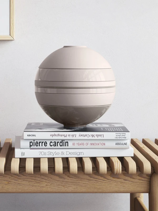 La Boule Pure Beige on a wooden table A Villeroy & Boch beige La Boule on a wooden table beside a Manufacture vase and books.