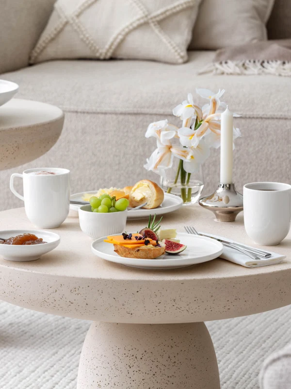 Breakfast with coffee, jam and sandwiches on a beige-coloured coffee table with Villeroy & Boch white Afina crockery.