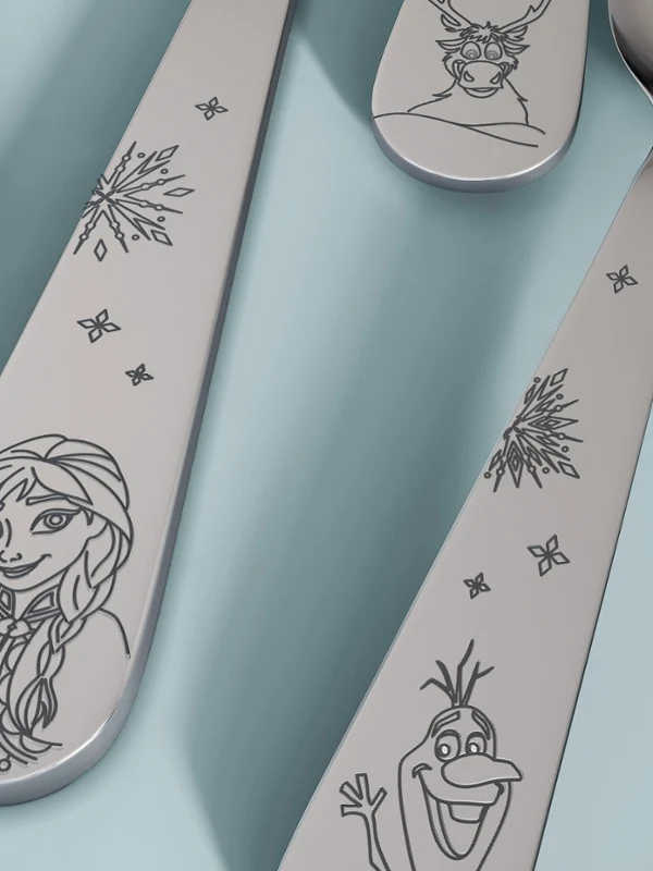 Cuatro cubiertos infantiles Disney Frozen sobre superficie azul claro Cuatro cubiertos infantiles Disney Frozen con grabados de personajes de «Frozen» sobre una superficie azul claro.