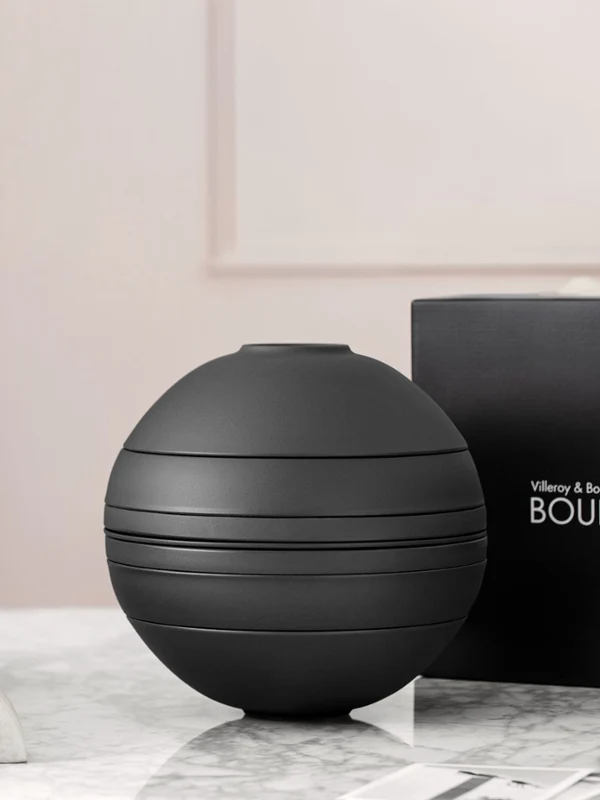 A black La Boule tableware set on a table with a black gift box behind it.