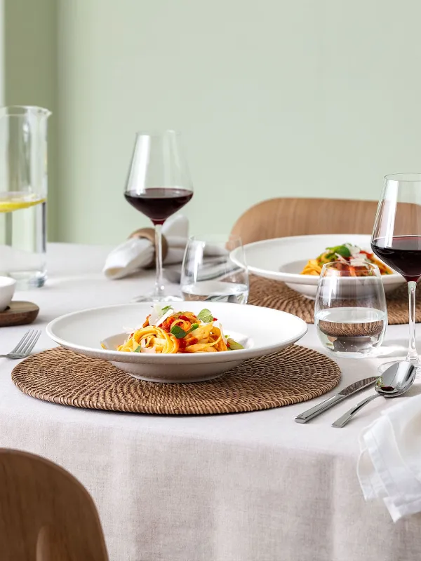 Primo piano di una tavola accogliente per due con la collezione Artesano Original di Villeroy & Boch – due piatti per pasta, set di ciotoline per salse e brocca d’acqua Entrée. Un’atmosfera fresca e rilassata, ideale per pasti condivisi e informali.