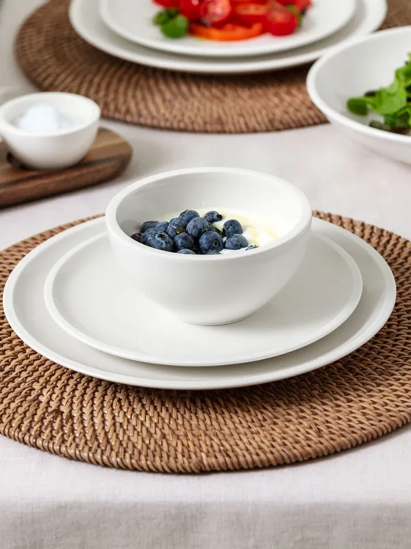 A bright, natural breakfast or lunch table setting with Villeroy & Boch Artesano Original tableware: breakfast plate, dinner plate, bowl, pasta bowl, and Piemont 30-piece cutlery set. A fresh and timeless arrangement in an earthy, minimalist style.