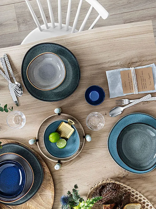 A wooden table with Villeroy & Boch Lave plates on top.