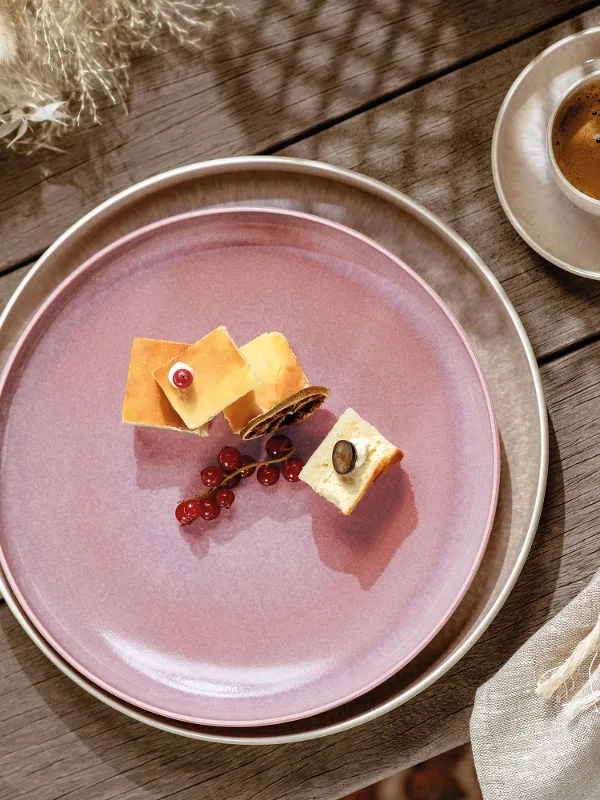 A pink like. by Villeroy & Boch Perlemor breakfast plate with a piece of cheese and a cup of coffee.