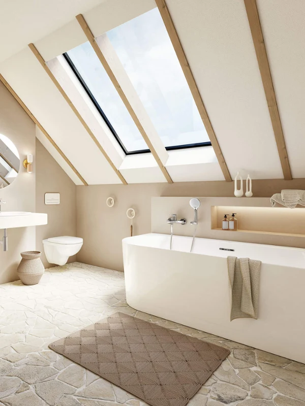 Loop & Friends bath in a light bathroom A Loop & Friends bath in a light bathroom with natural stone tiles and a sloping ceiling