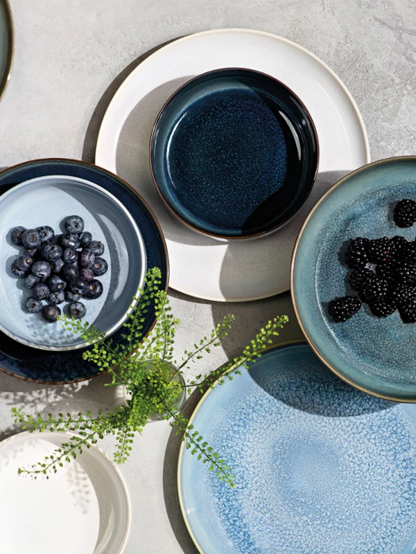 Verschiedene Teile von Crafted mit Blaubeeren oder Brombeeren, kunstvoll arrangiert auf einer strukturierten Oberfläche.