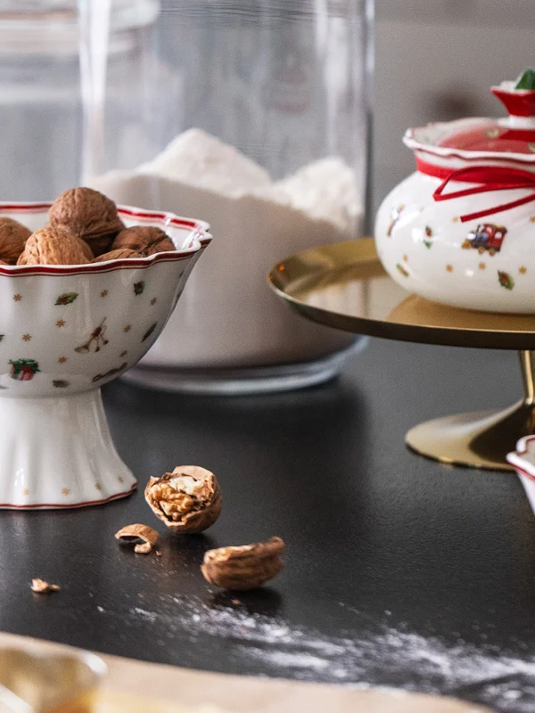 Villeroy & Boch "Toy's Delight" ceramic bowls filled with walnuts and butter on a dark countertop, surrounded by sprinkled flour and cracked walnuts.