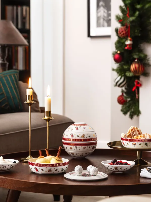 Ambiente natalizio con albero di Natale addobbato, camino acceso e tavolo su cui è posata La petite Boule Toy’s Delight.