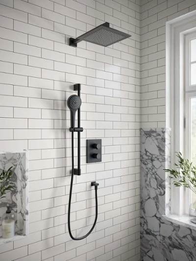 Universal Showers Regendusche in weiß gefliester Dusche Eine moderne Dusche verfügt über einen quadratischen Duschkopf und eine Handbrause vor einer Wand mit weißen U-Bahn-Fliesen, mit einem Fenster und natürlichem Licht an der Seite sowie einem Marmor-Akzent mit Duschutensilien.