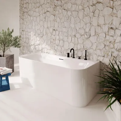 Bagno moderno con vasca free-standing bianca Loop & Friends su una parete di pietra testurizzata dove la luce del sole proietta ombre morbide