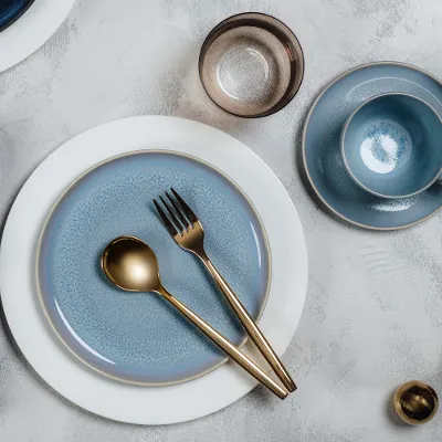 Elegant table decoration with blue Crafted crockery and white Royal crockery, gold MetroChic cutlery and a matching napkin.