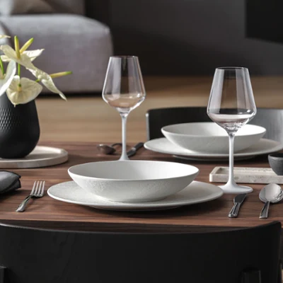 Manufacture Rock, Collier Vase, Travertine & Noir Table Set with Lantern and Candle Holder Un ensemble soigné comprenant Manufacture Rock, vase Collier, Travertine, lanterne Noir et bougeoir, dans une élégante mise en table moderne.