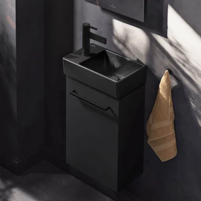 Bathroom washstand in an all-black style Modern bathroom with an illuminated black Collaro washstand, a matt black Antao washbasin, a round More to See Lite mirror and decoration objects.