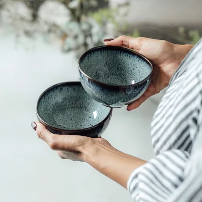 Kleine Lave Gris Dip-Schüsseln Eine Person hält zwei Keramikschüsseln „Lave Gris“ von Villeroy & Boch mit einer unikaten Glasur.